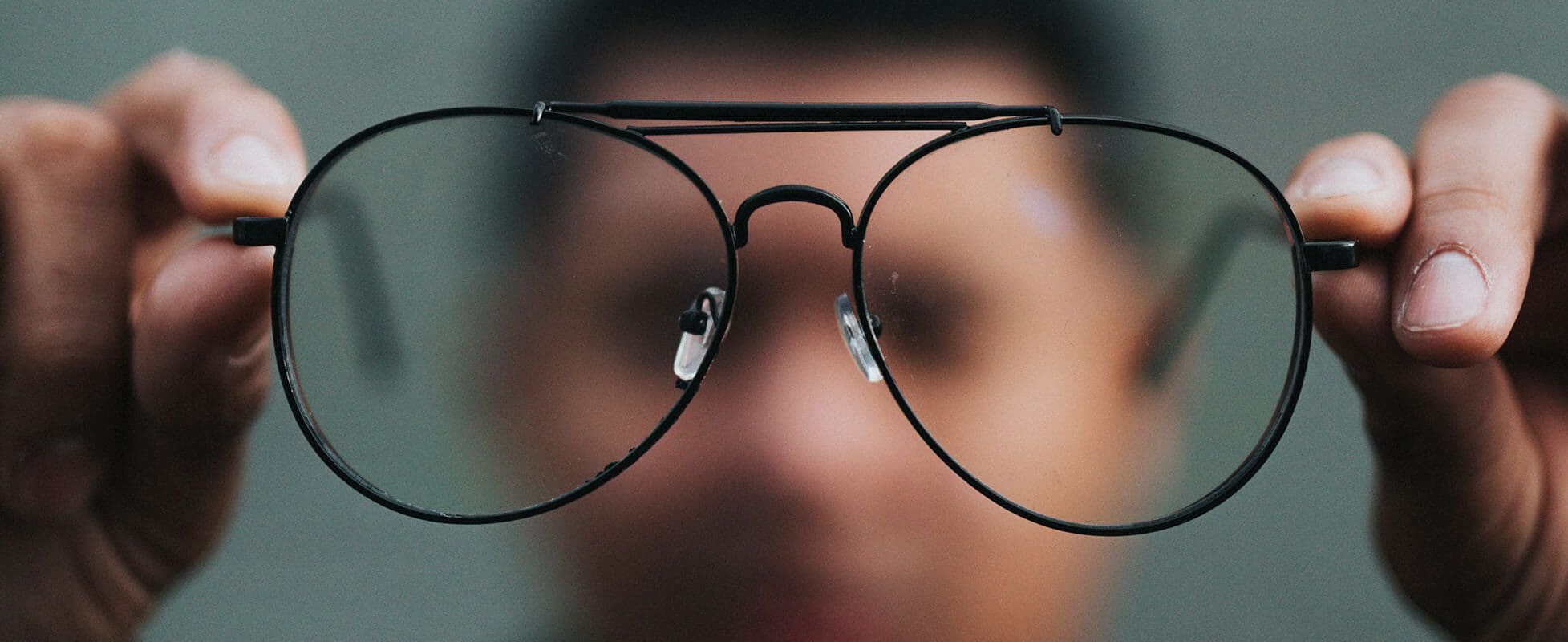 man holding glasses to see clearly man holding glasses to see clearly