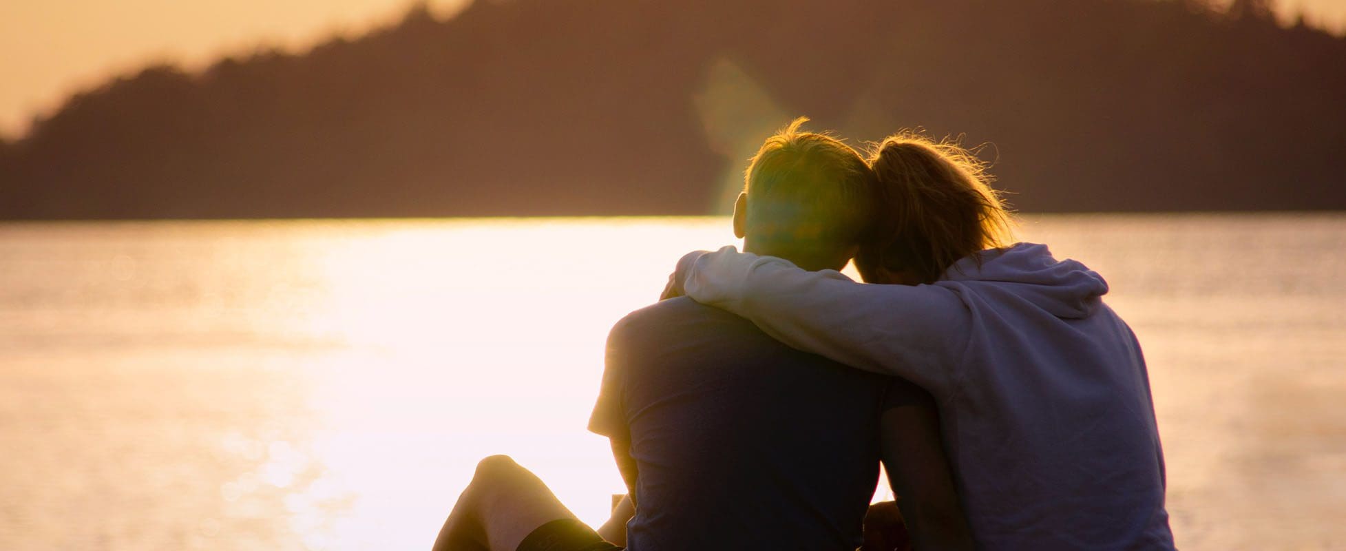people hugging near lake